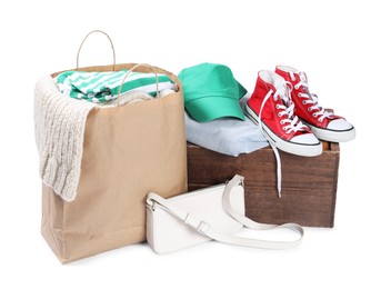 Photo of Packed used clothes, bag and shoes isolated on white