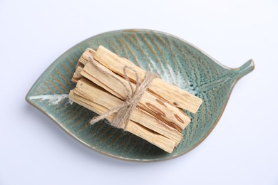 Photo of Bunch of palo santo sticks on white background, top view