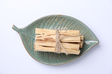 Photo of Bunch of palo santo sticks on white background, top view