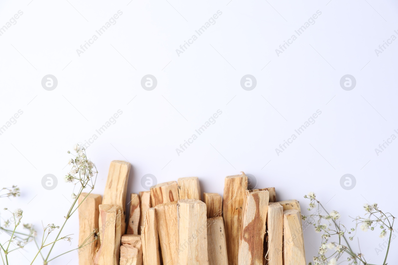 Photo of Palo santo sticks and gypsophila flowers on white background, flat lay. Space for text