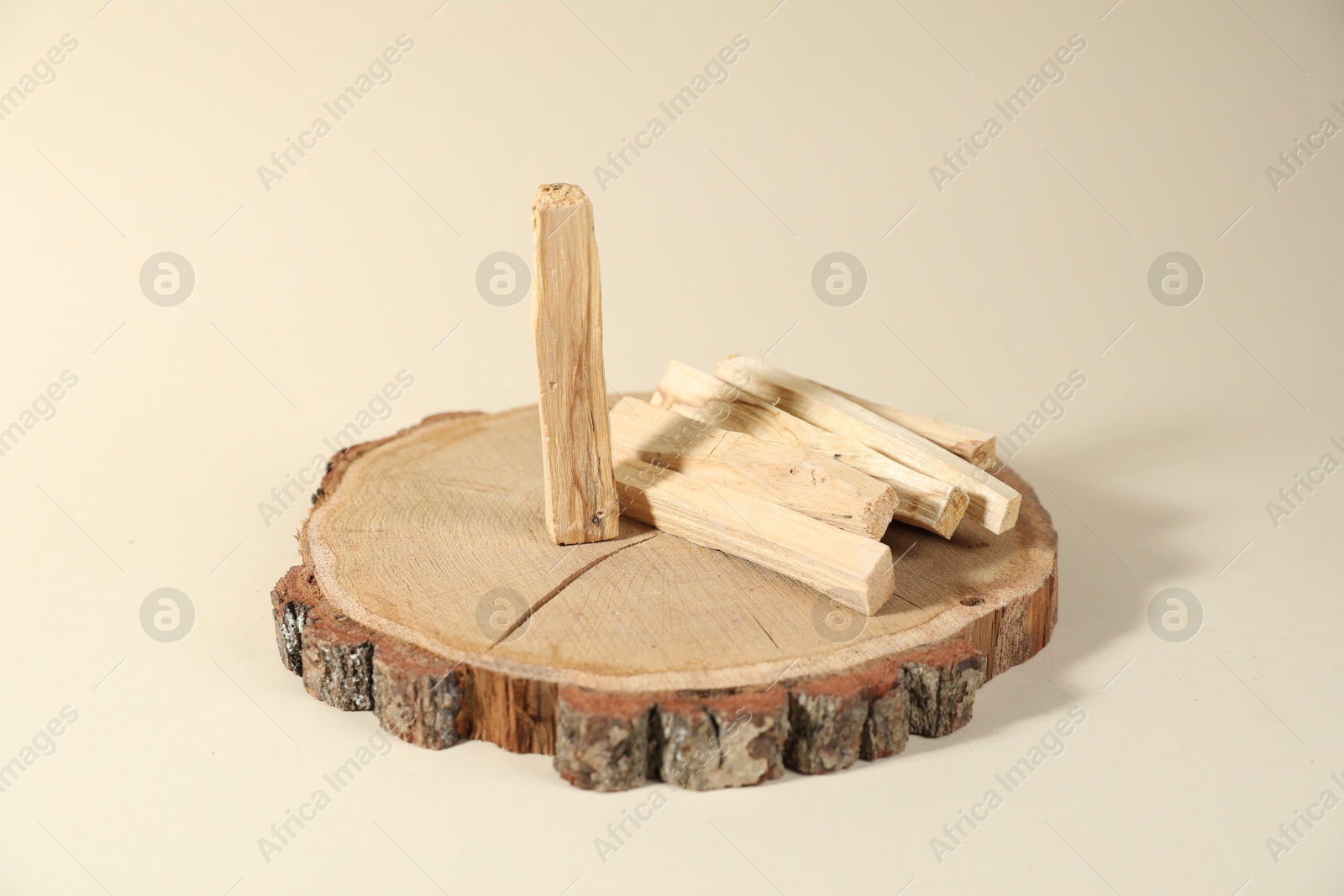 Photo of Palo santo sticks on beige background, closeup