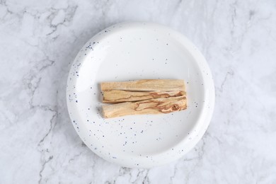 Photo of Palo santo sticks on white marble table, top view