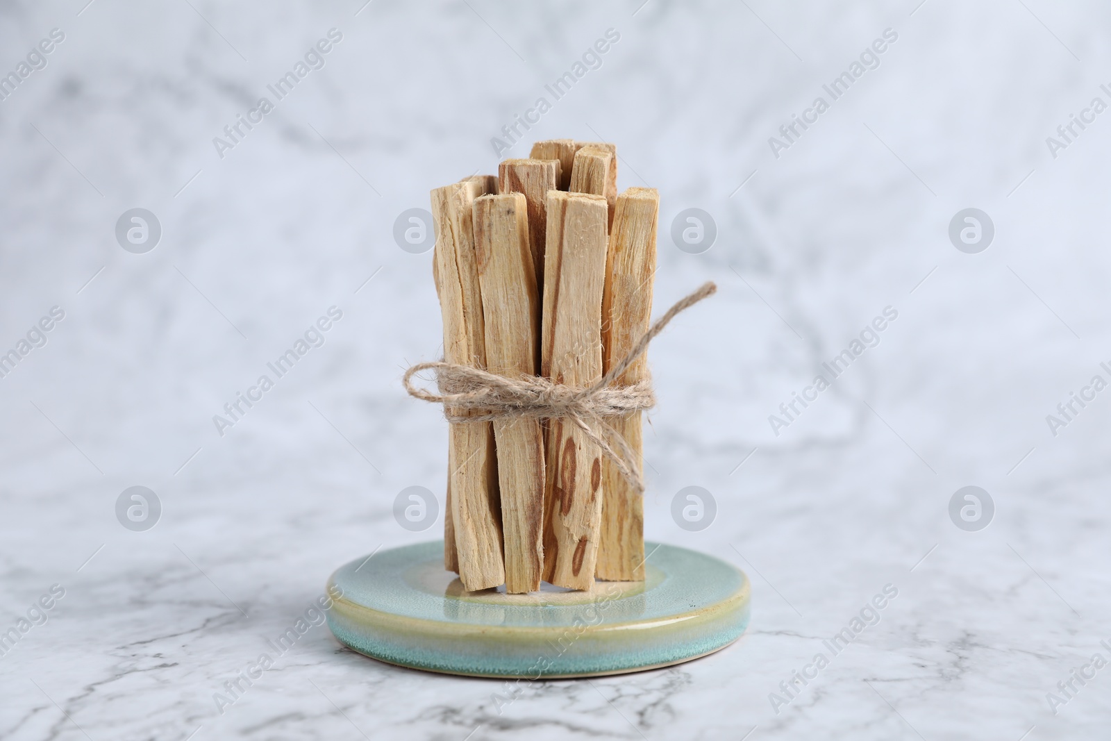 Photo of Bunch of palo santo sticks on white marble table