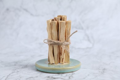 Photo of Bunch of palo santo sticks on white marble table