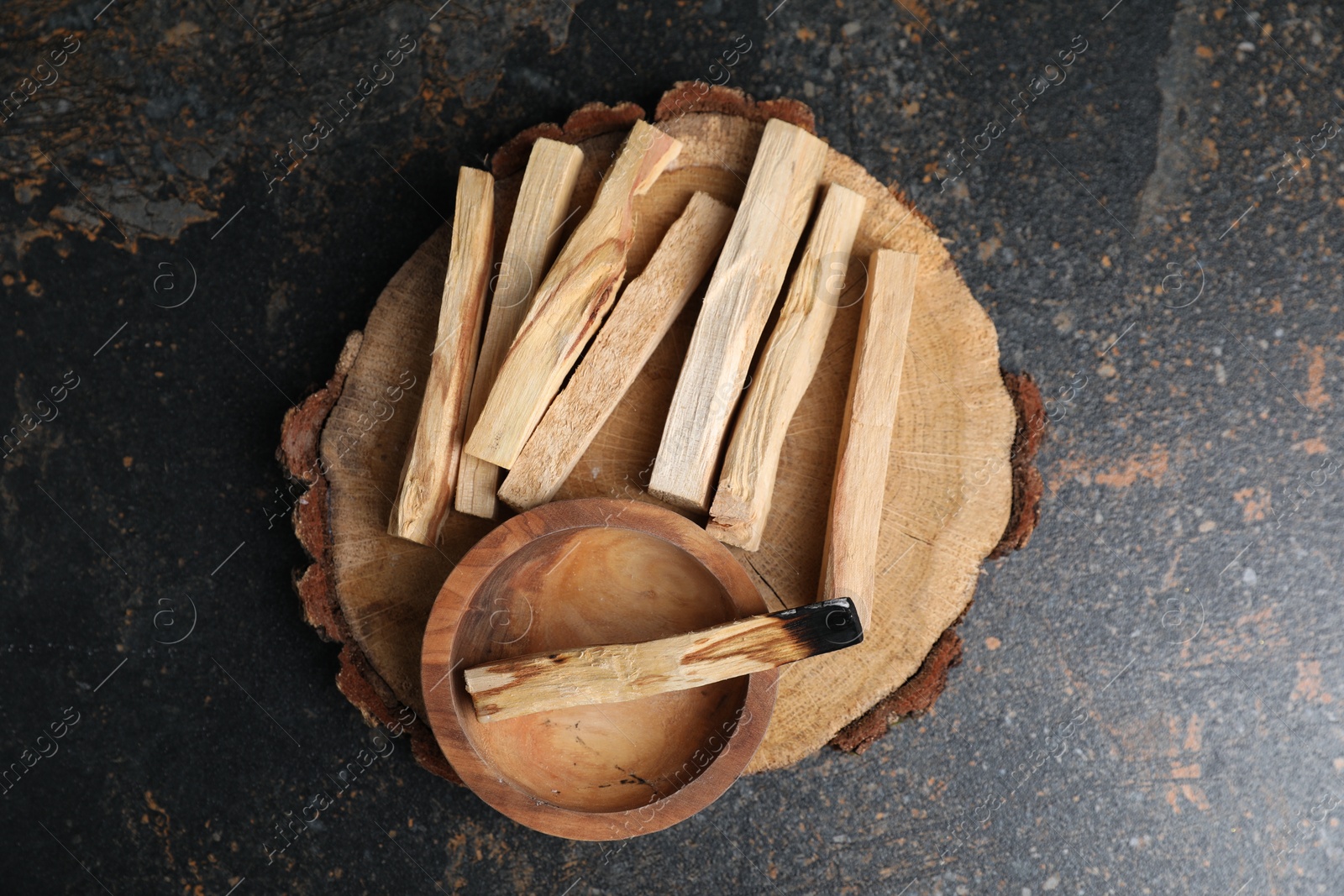 Photo of Palo santo sticks and burnt one on dark table, top view