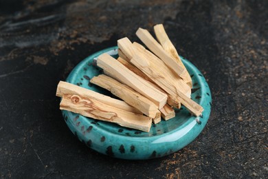 Photo of Palo santo sticks on dark table, closeup