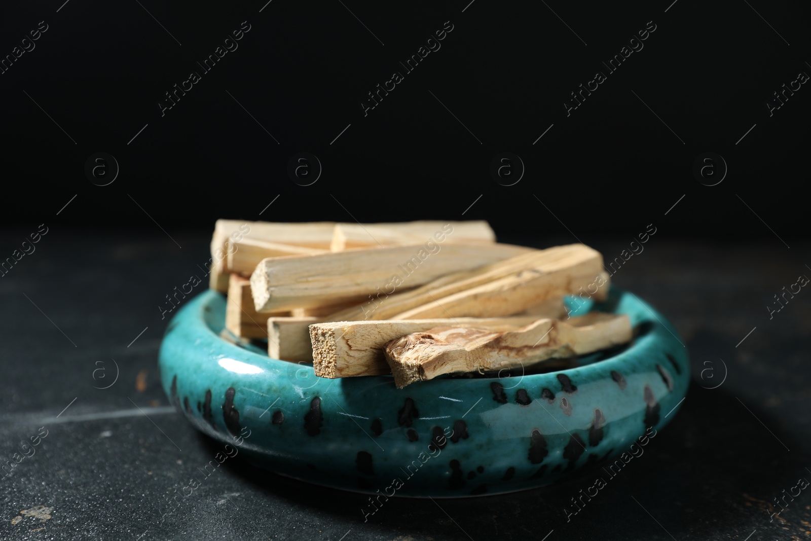 Photo of Palo santo sticks on dark table, closeup