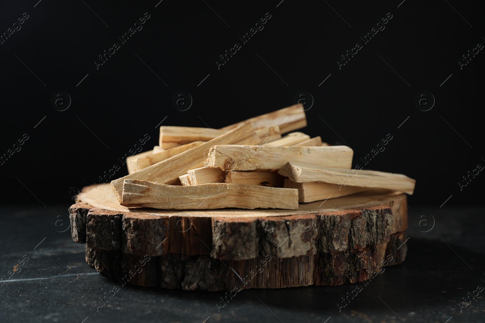 Photo of Palo santo sticks on dark table, closeup