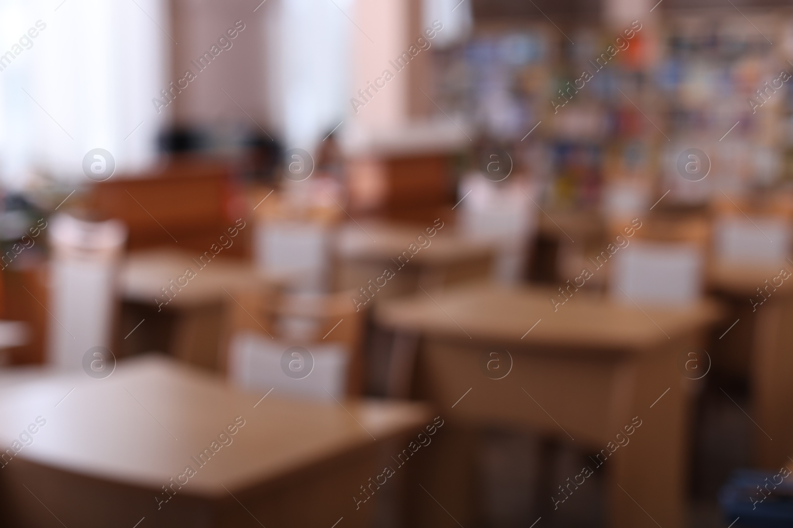 Photo of Desks and chairs in public library room, blurred view