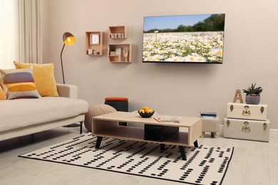 Image of TV set with nature landscape on screen in room