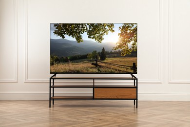 Image of TV set with nature landscape on screen in room