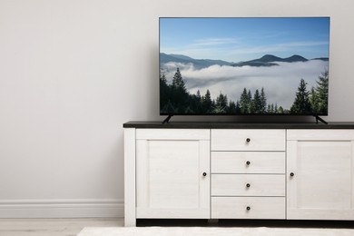 Image of TV set with nature landscape on screen in room