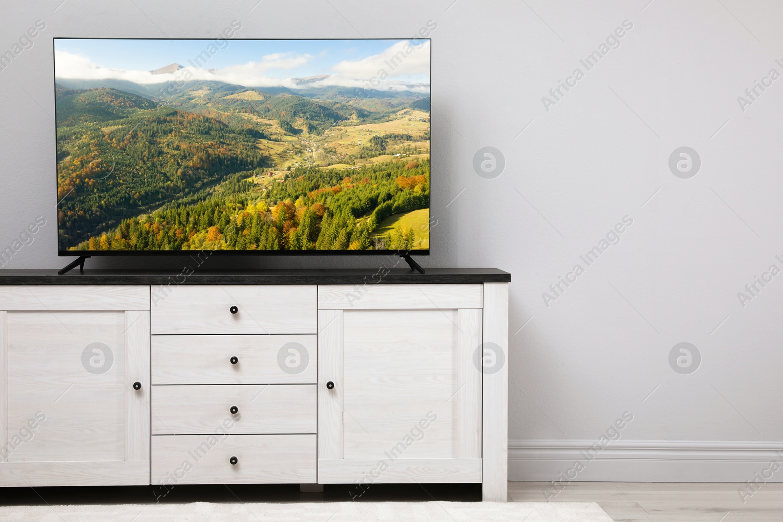 Image of TV set with nature landscape on screen in room