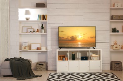 Image of TV set with nature landscape on screen in room