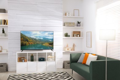 Image of TV set with nature landscape on screen in room