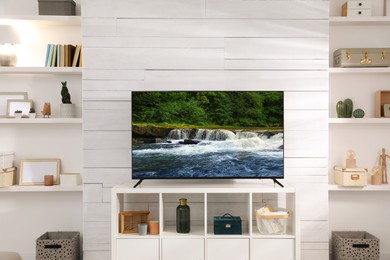 Image of TV set with nature landscape on screen in room