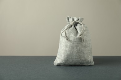 Burlap sack on gray surface against light background, space for text