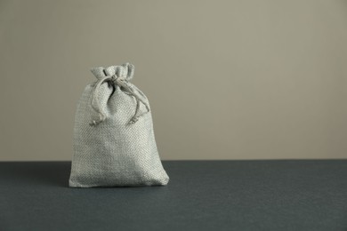 Burlap sack on gray surface against light background, space for text