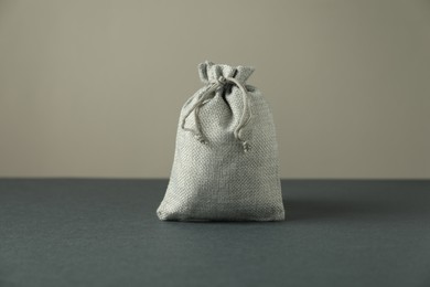 Burlap sack on gray surface against light background