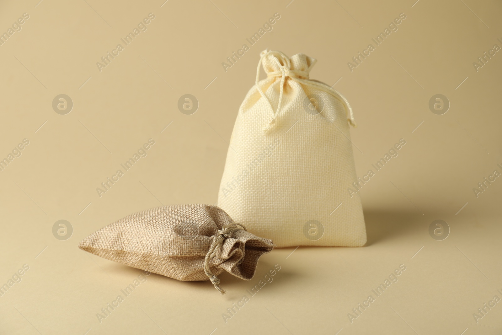 Photo of Two color burlap sacks on beige background