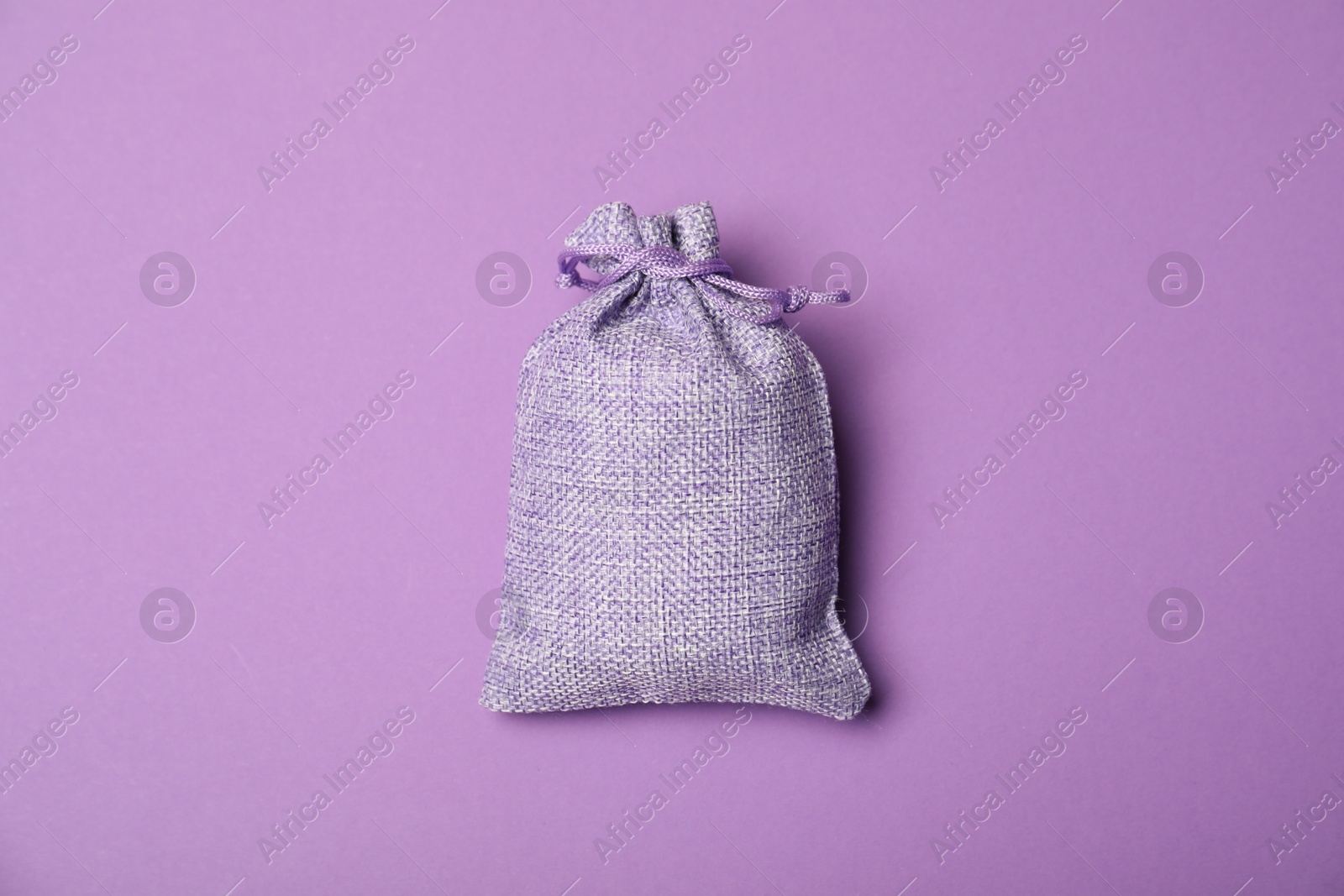 Photo of One burlap sack on violet background, top view