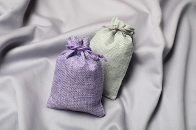 Photo of Burlap sacks on gray fabric, top view