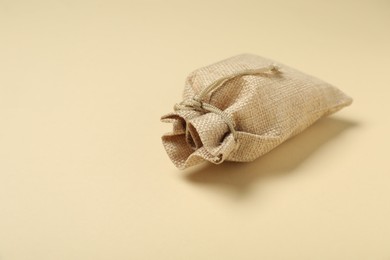 Photo of Burlap sack on beige background, space for text