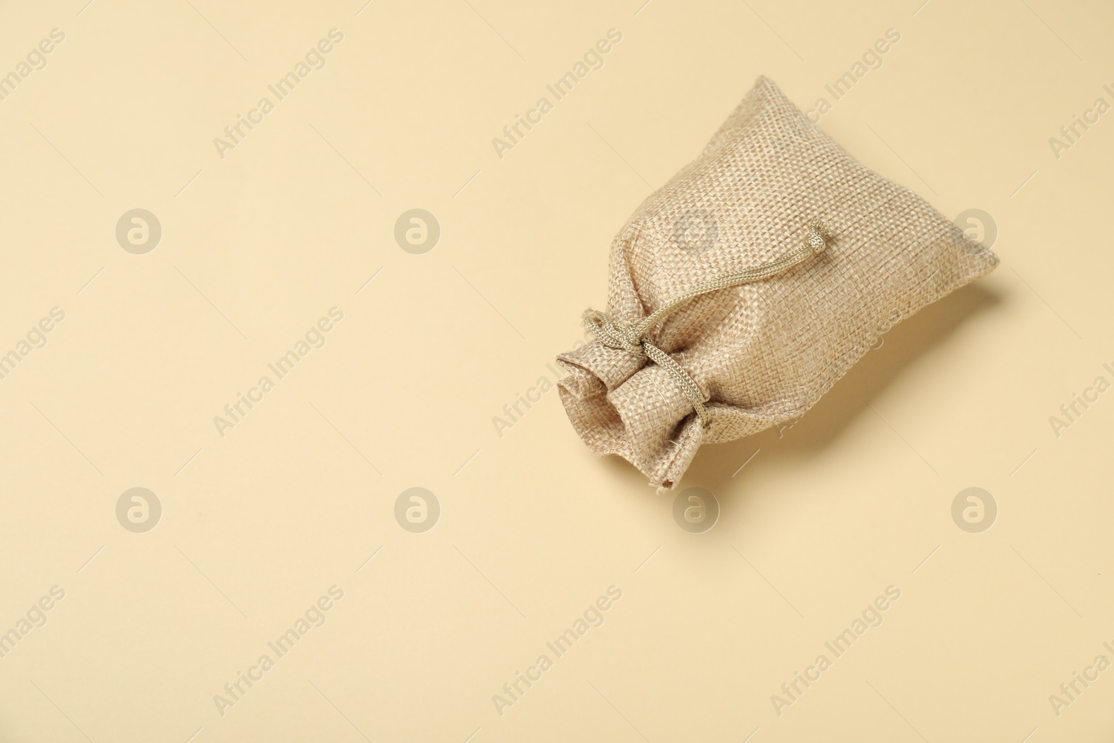 Photo of Burlap sack on beige background, top view. Space for text