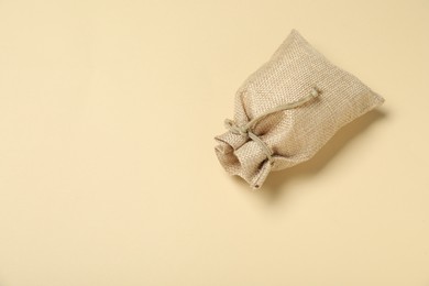 Photo of Burlap sack on beige background, top view. Space for text