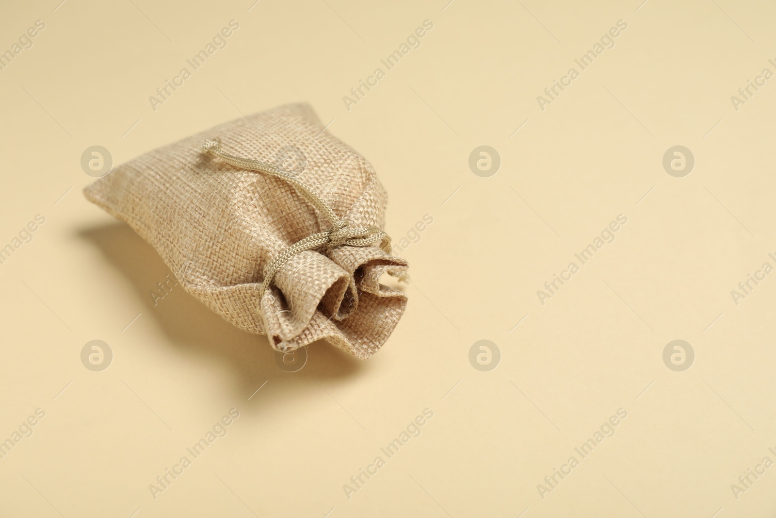 Photo of Burlap sack on beige background, space for text