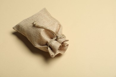 Photo of One burlap sack on beige background, space for text