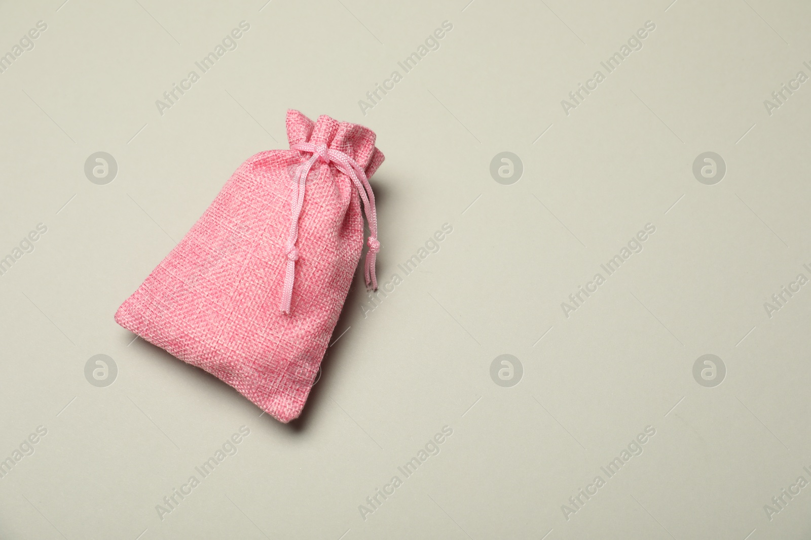 Photo of Pink burlap sack on light gray background, top view. Space for text