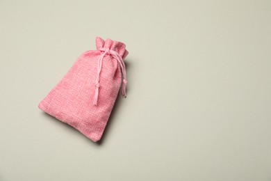 Photo of Pink burlap sack on light gray background, top view. Space for text