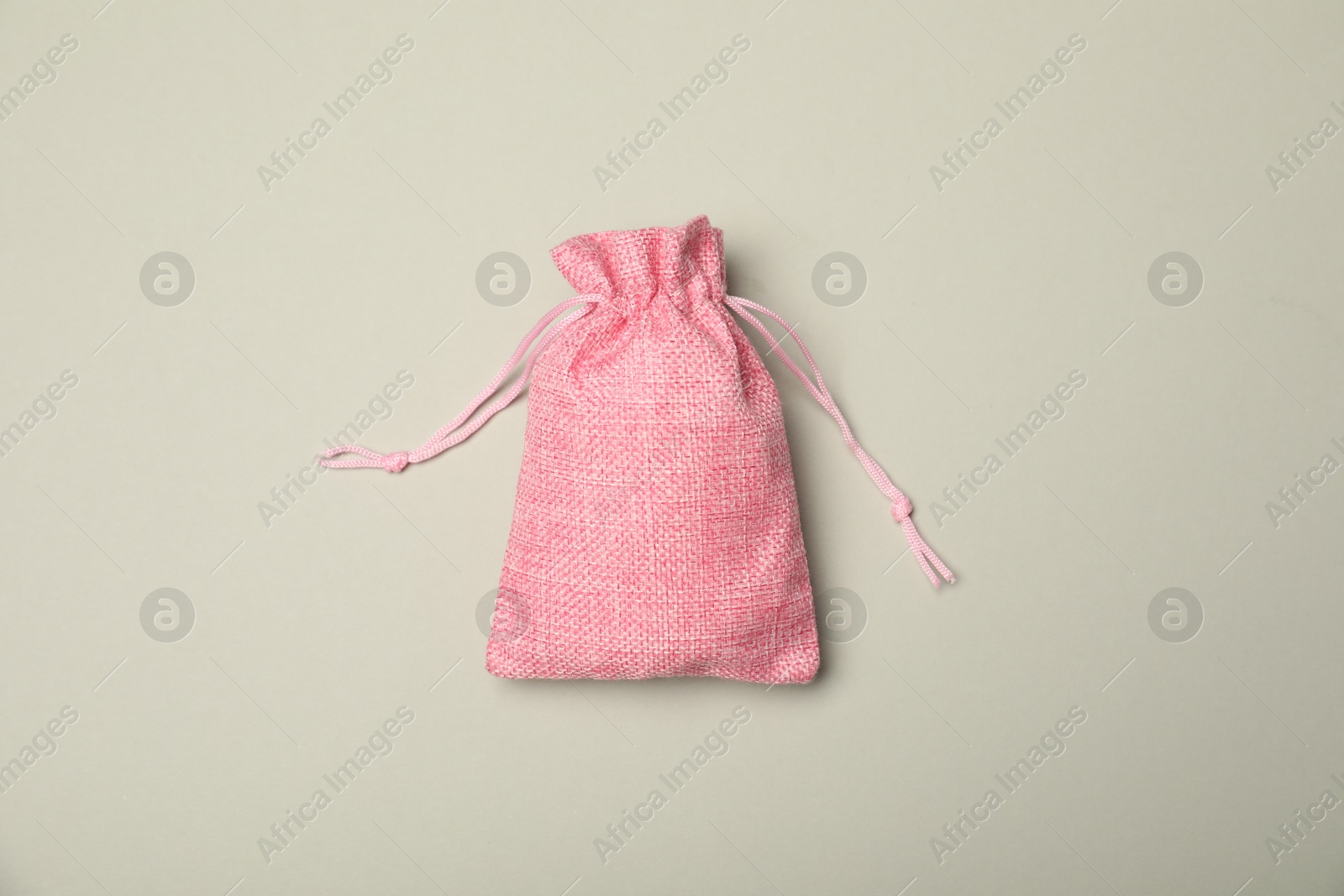 Photo of Pink burlap sack on light gray background, top view