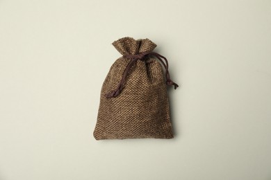 Photo of Brown burlap sack on light gray background, top view