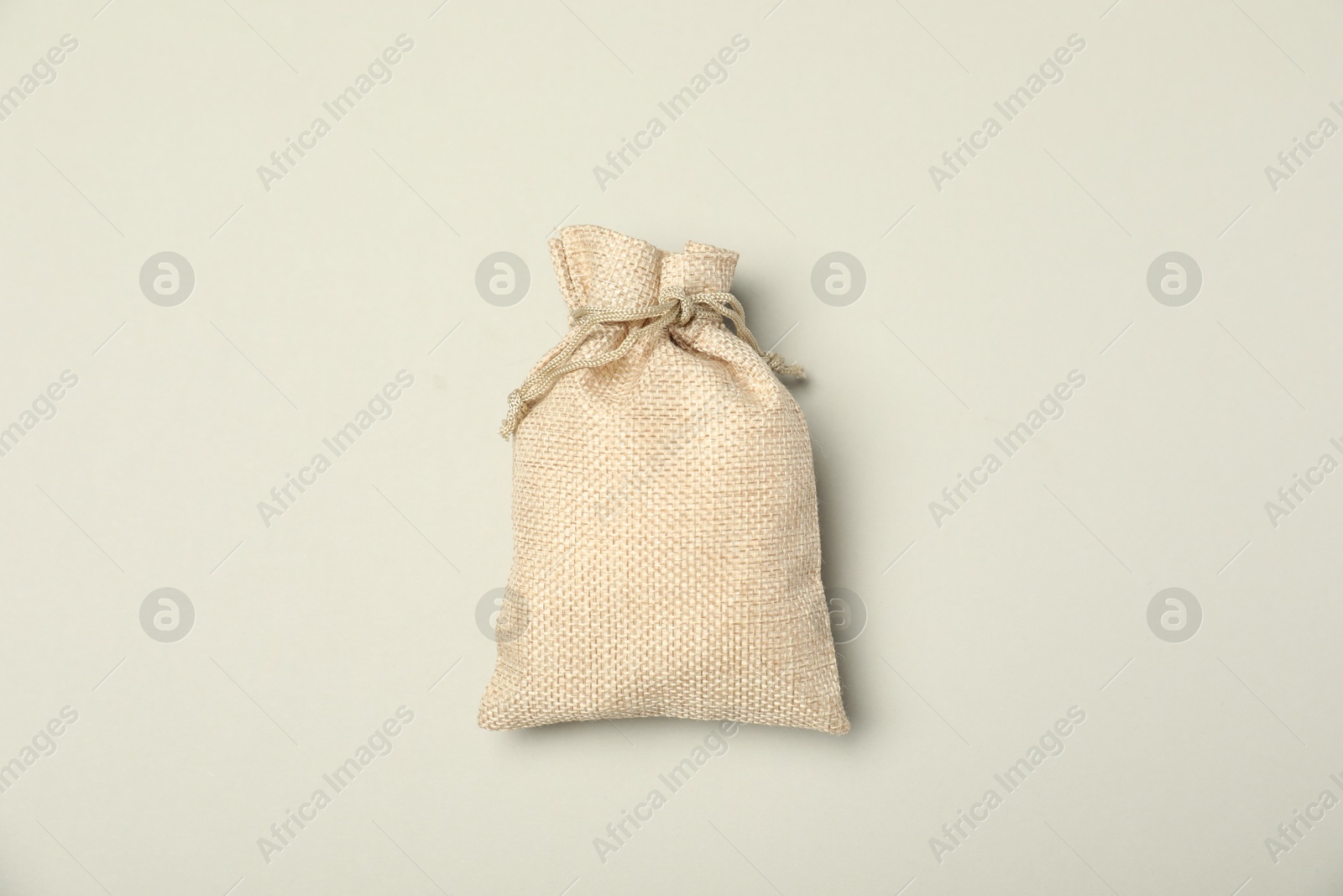 Photo of Beige burlap sack on light gray background, top view