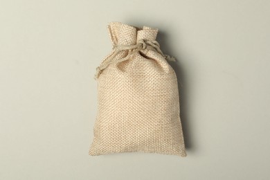 Photo of Beige burlap sack on light gray background, top view