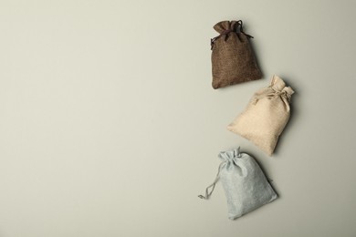 Photo of Burlap sacks on light gray background, flat lay. Space for text