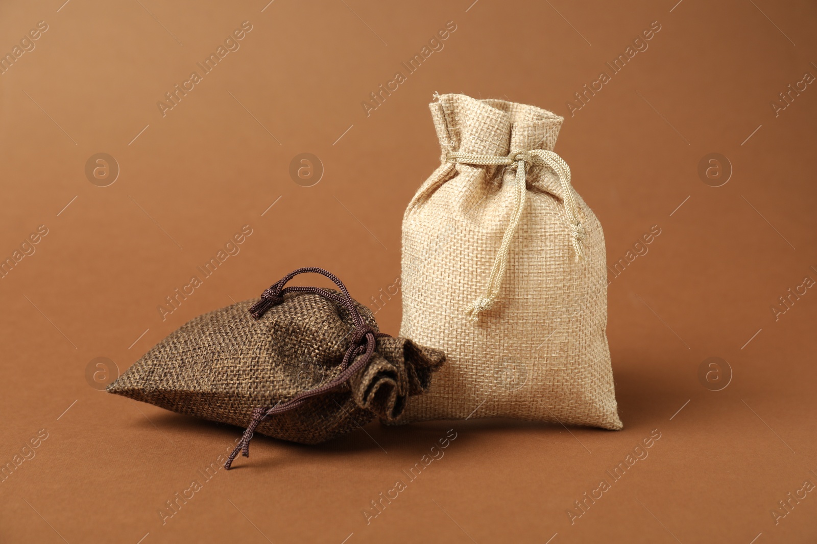 Photo of Two color burlap sacks on brown background