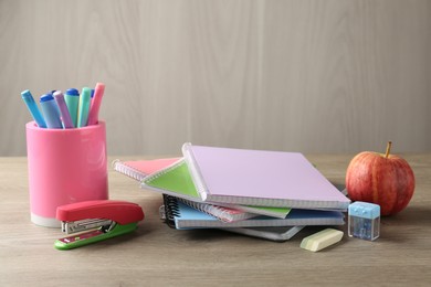 Photo of Doing homework. Notebooks, apple and stationery on wooden desk. Space for text