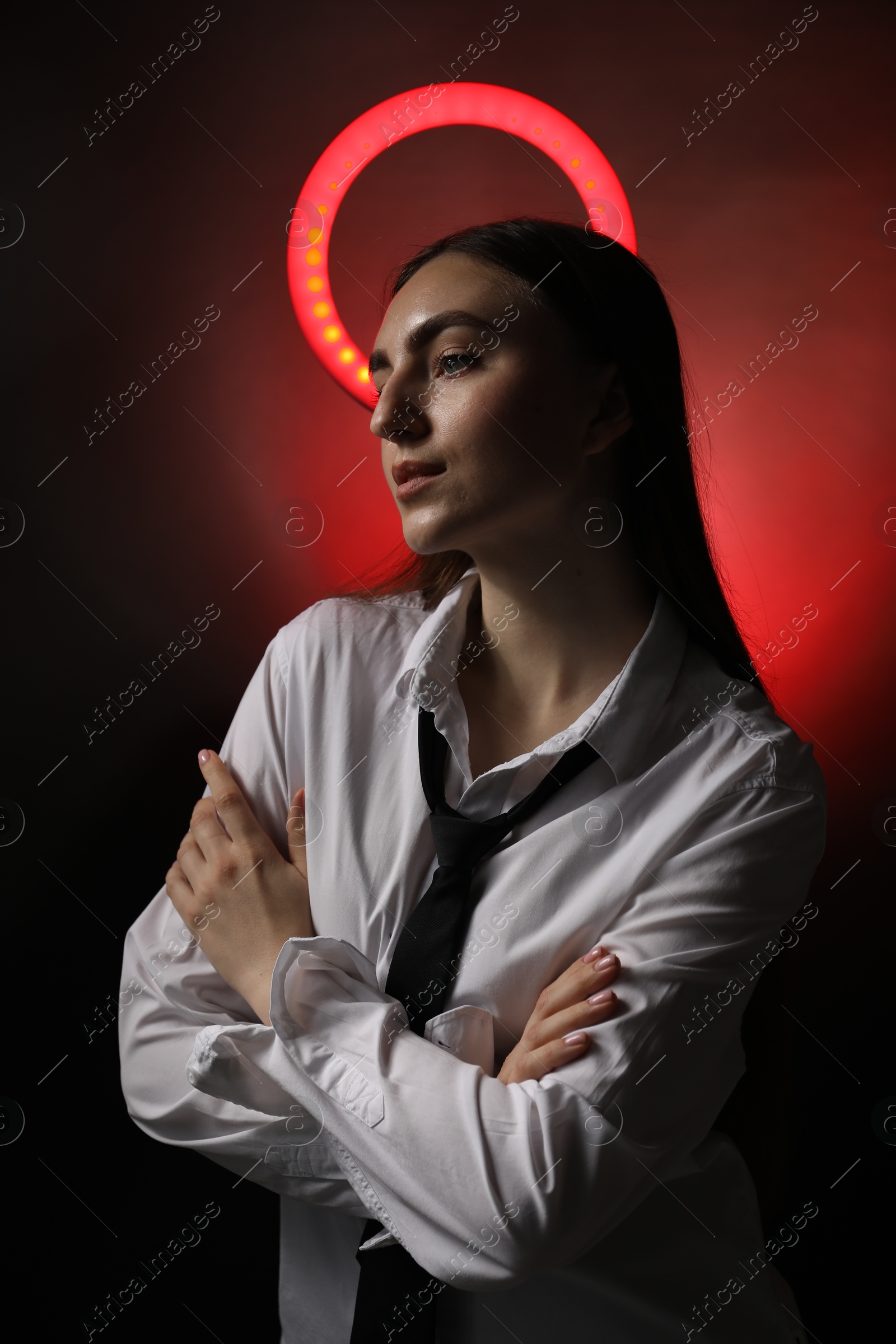 Photo of Beautiful woman with ring lamp on dark red background