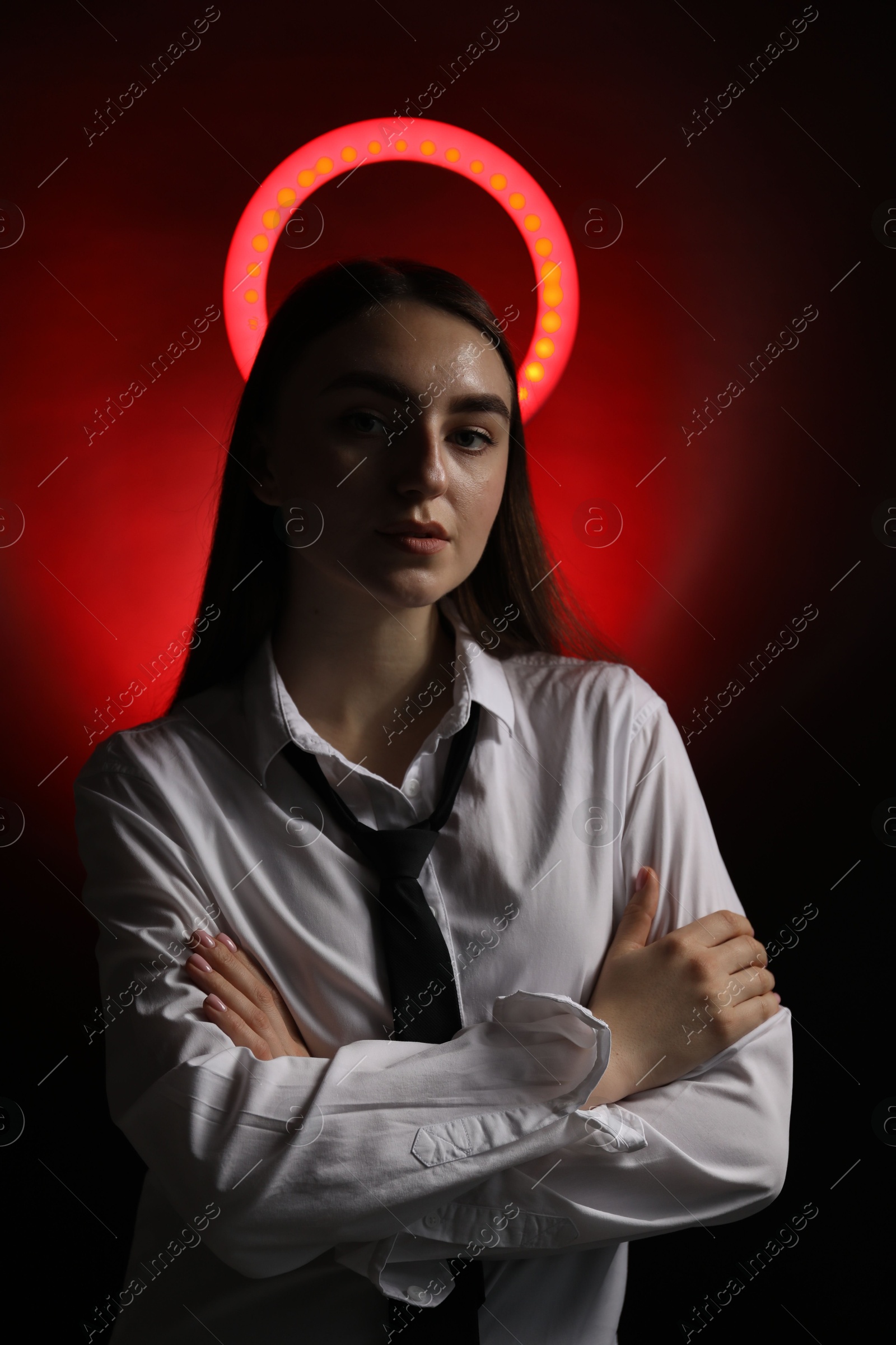 Photo of Beautiful woman with ring lamp on dark red background