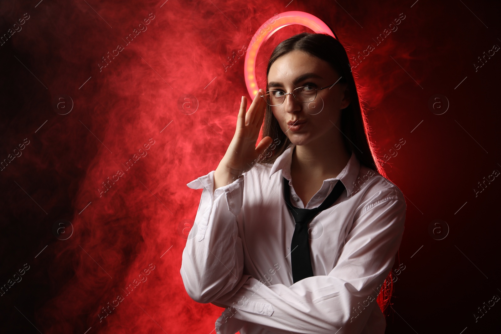 Photo of Beautiful woman with ring lamp wearing glasses on dark red background in smoke, space for text