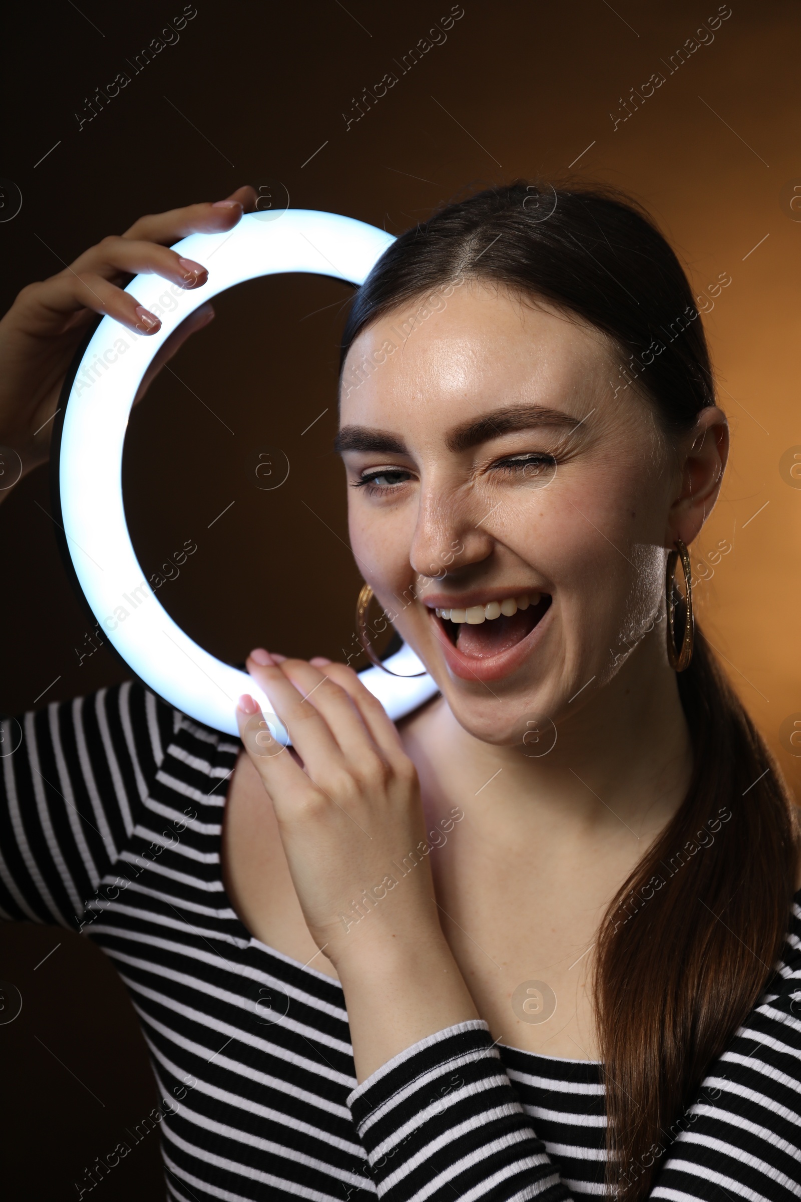 Photo of Beautiful woman with ring lamp on dark background