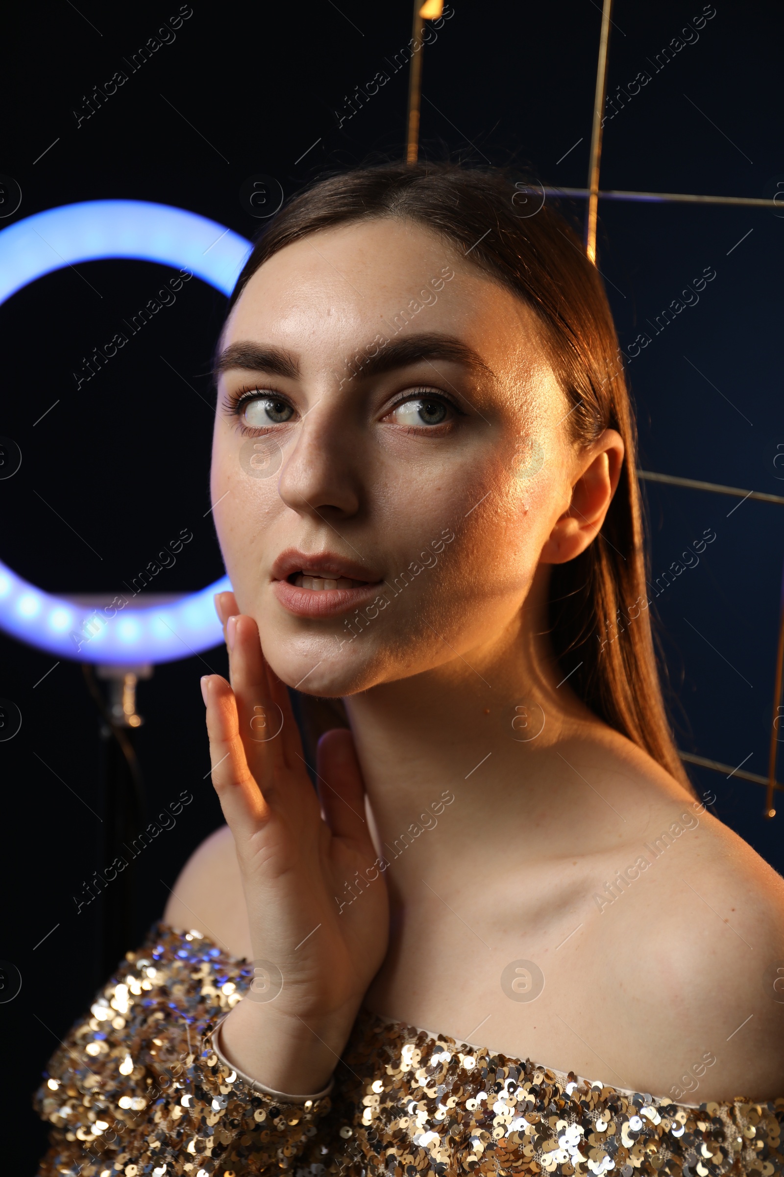 Photo of Beautiful woman with grid and ring lamp on dark blue background