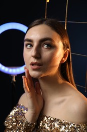 Photo of Beautiful woman with grid and ring lamp on dark blue background