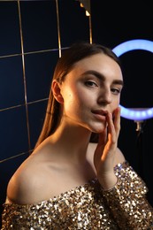 Photo of Beautiful woman with grid and ring lamp on dark blue background