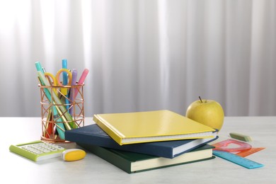 Photo of Doing homework. Notebooks, apple and stationery on white desk. Space for text