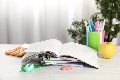 Photo of Doing homework. Notebook with math assignment, apple and stationery on white desk. Space for text