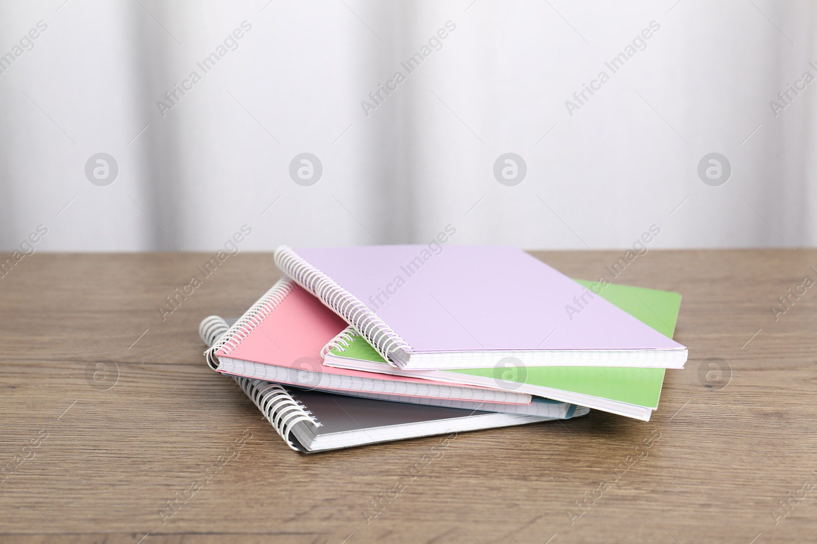 Photo of Doing homework. Stack of notebooks on wooden desk. Space for text